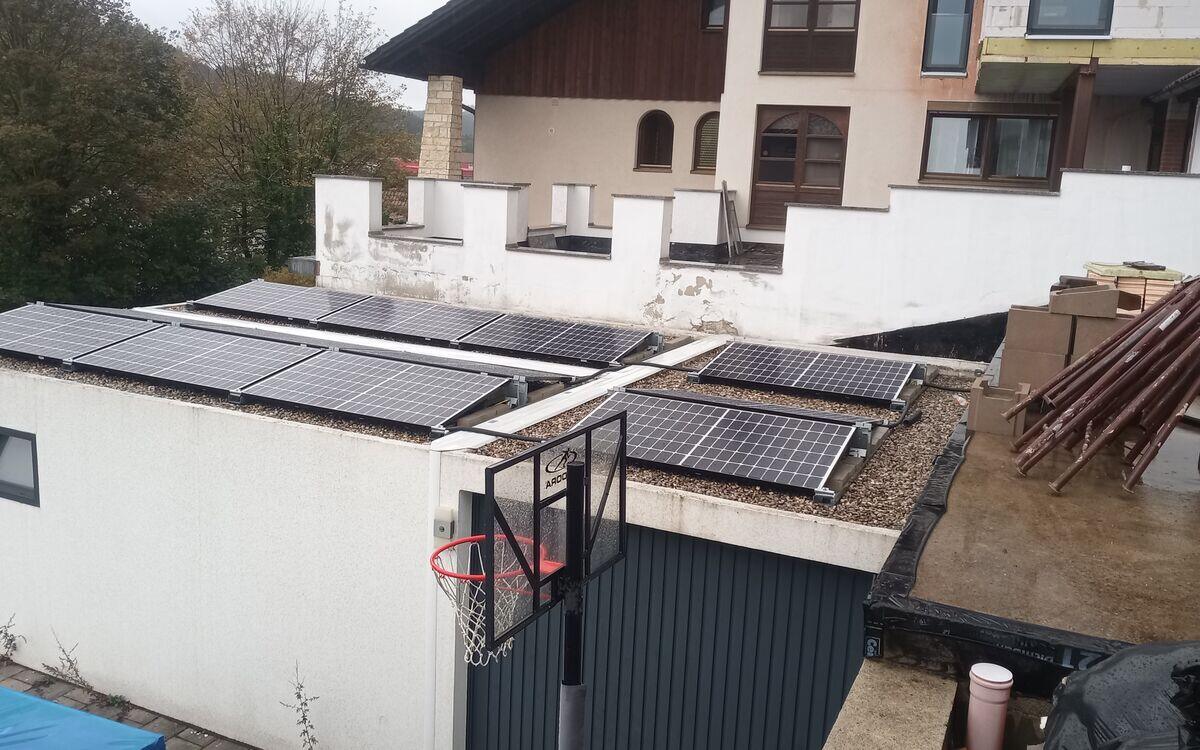 Aufgeständerte Solarmodule auf dem Kiesflachdach eines Nebengebäudes