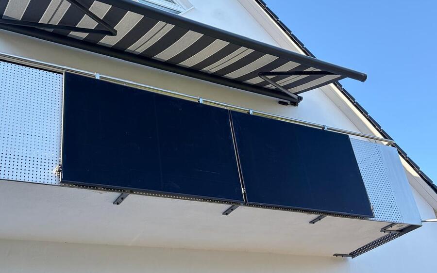 Zwei Solarmodule aussen am Balkon eines Wohnhauses in Stockheim, darüber die Markise