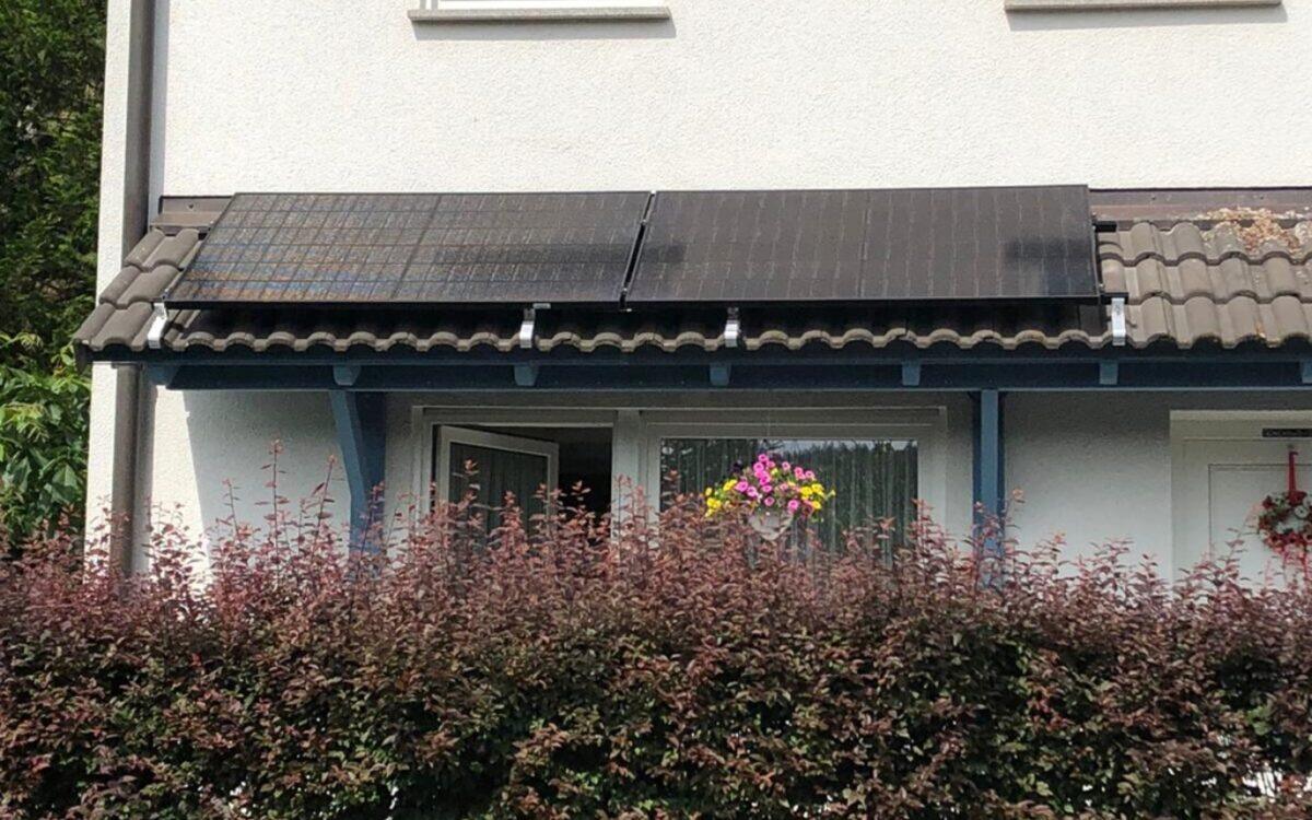 Vier Solarmodule flach auf dem Ziegel-Vordach einer überdachten Terrasse