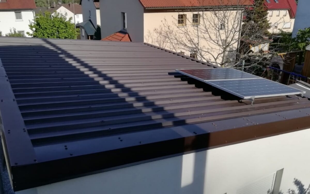 Aufgeständertes Solarmodul auf dem Blechdach eines Anbaus, nach Süden ausgerichtet